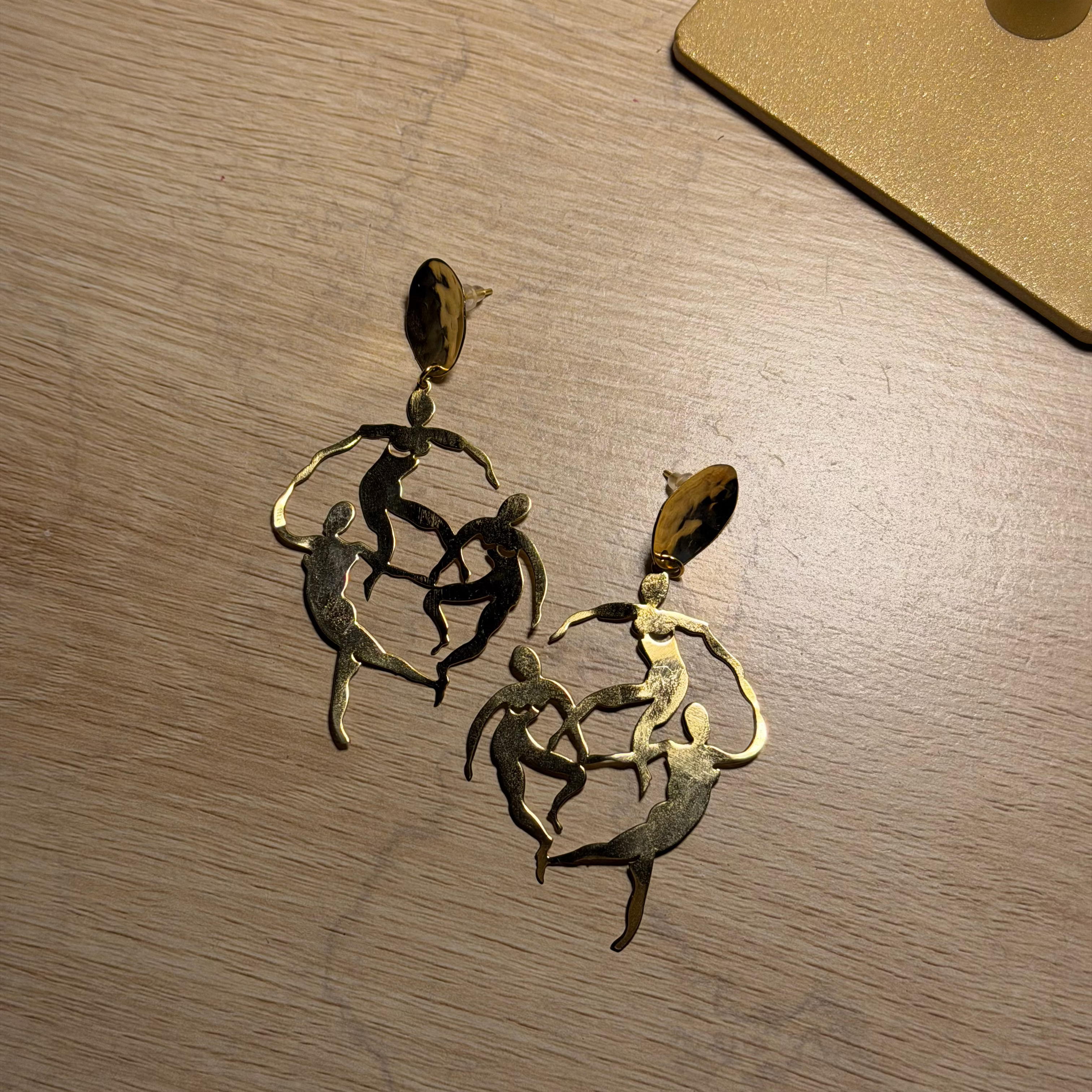 A pair of gold-toned dangle dancing earrings 

